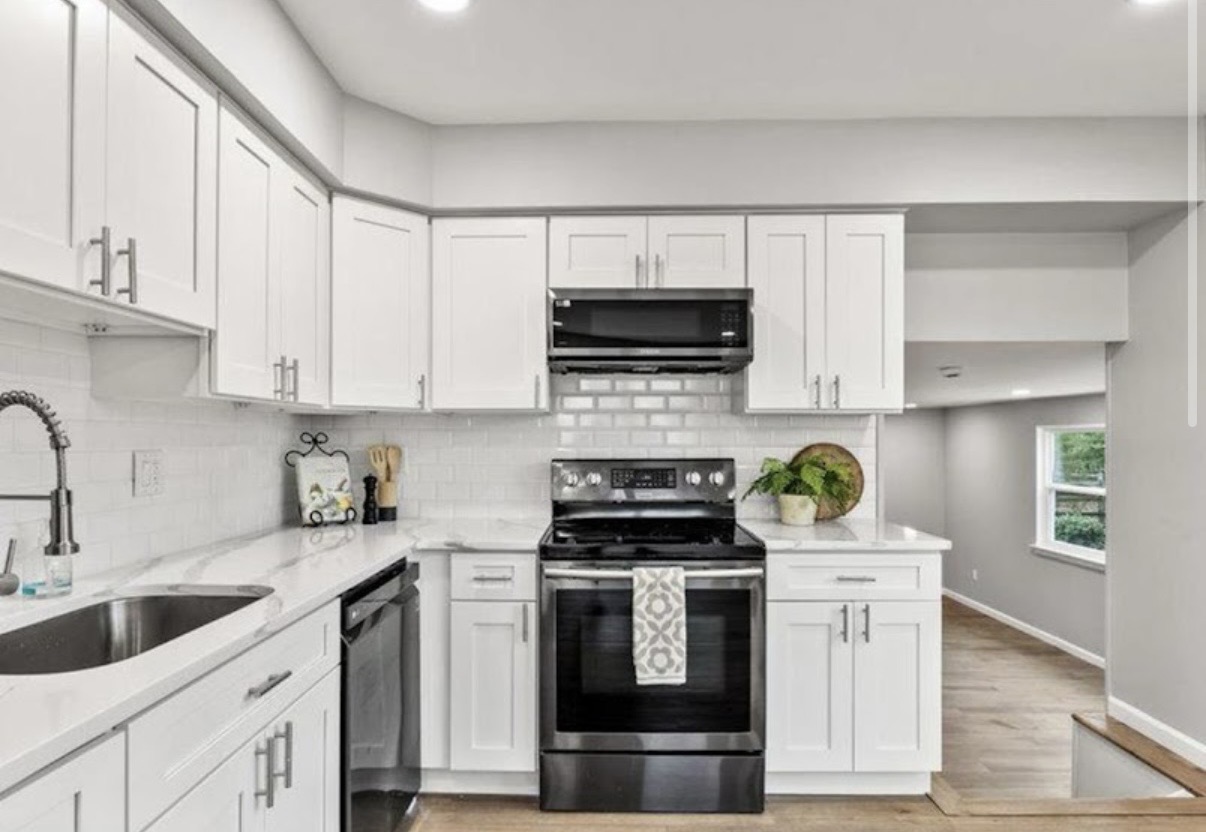 Bright all-white kitchen with quartz counters and subway backsplash